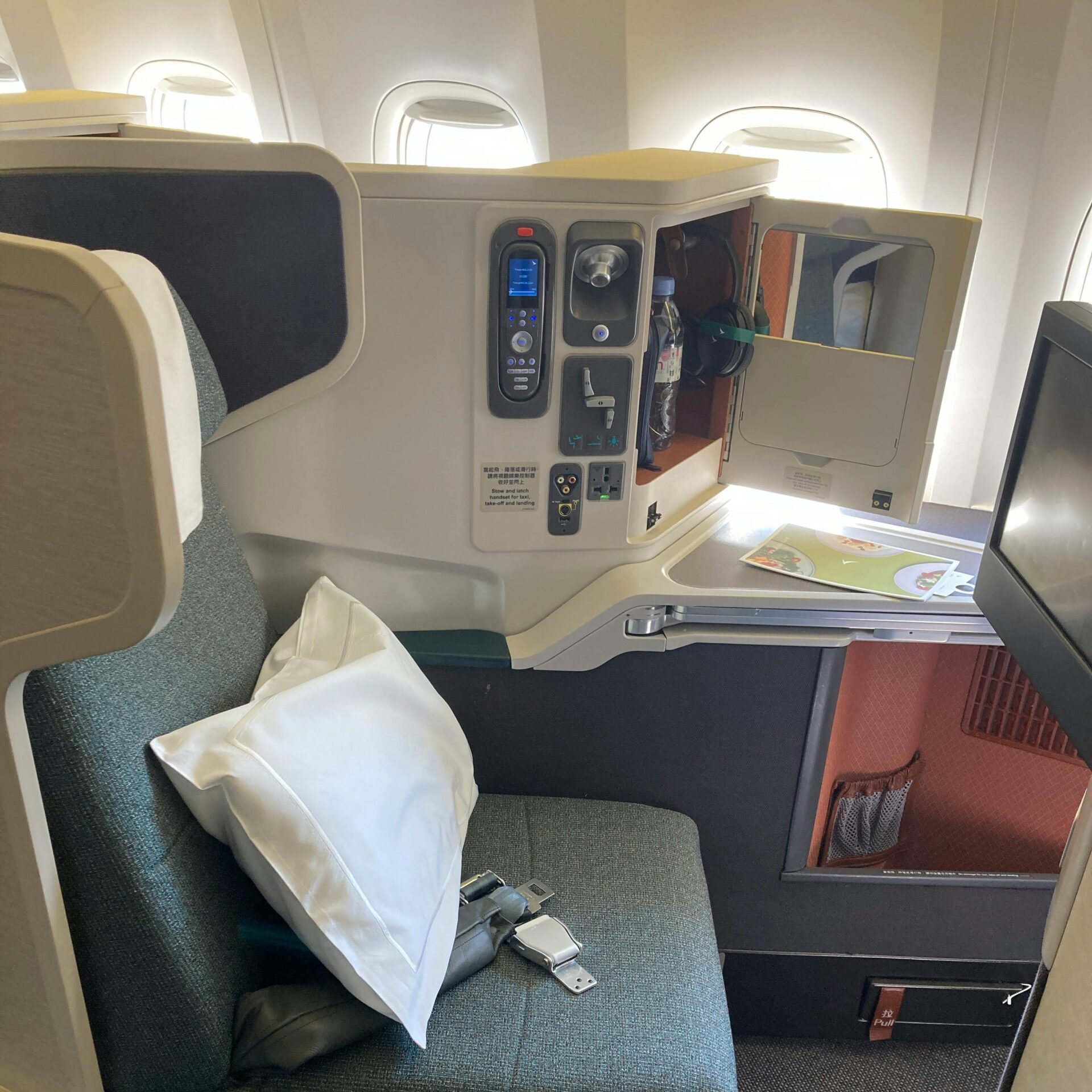 Modern and comfortable business class airplane seat with amenities for a premium travel experience.